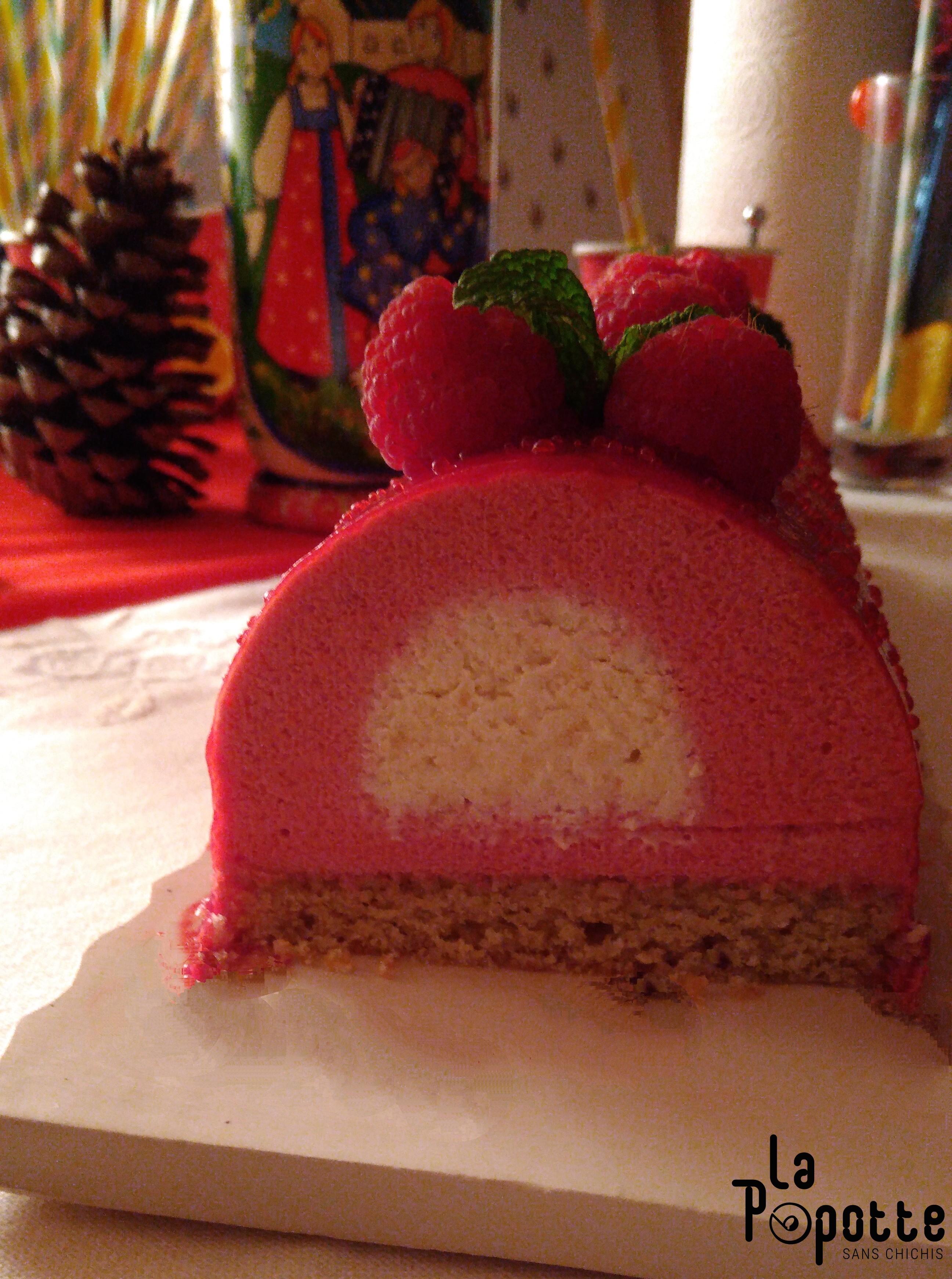 Bûche framboise, cœur nougat sur un financier pistache coupe